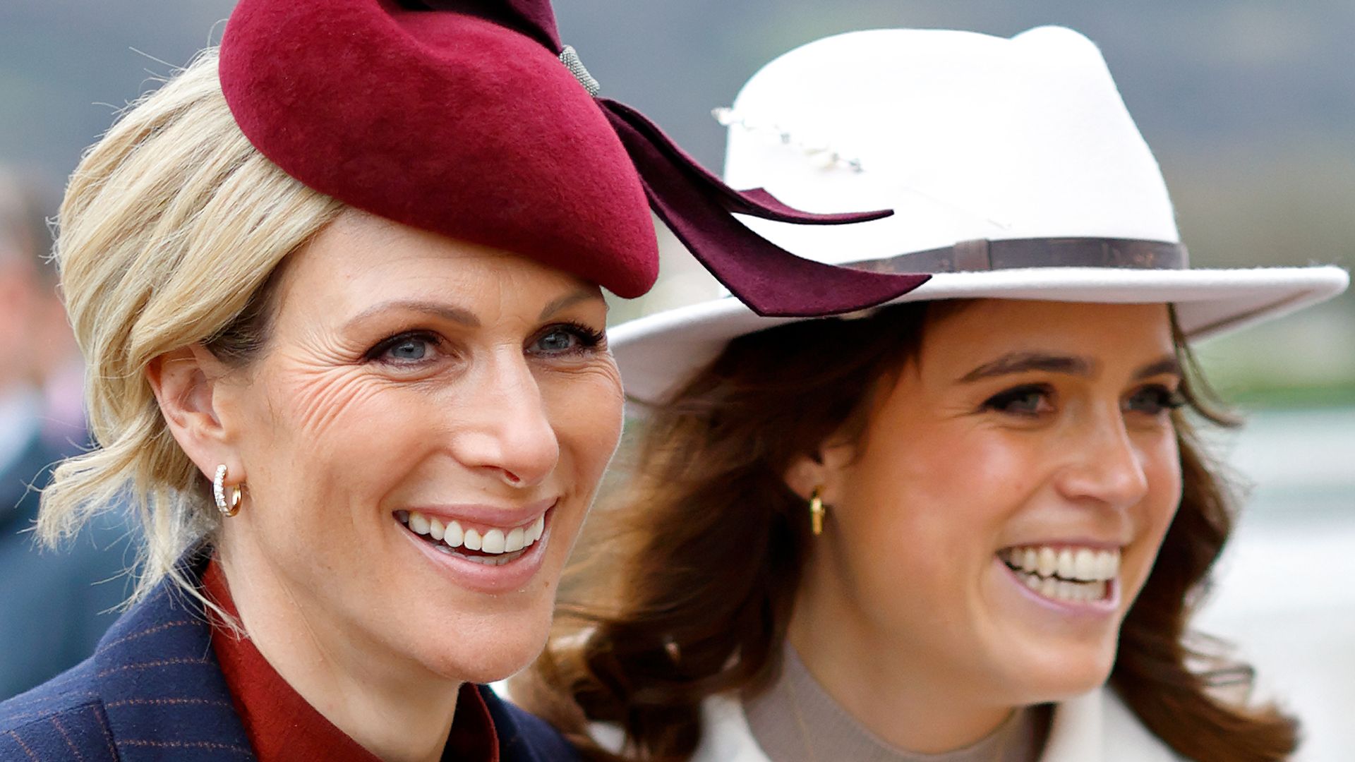 zara tindall and princess eugenie smiling at cheltenham festival