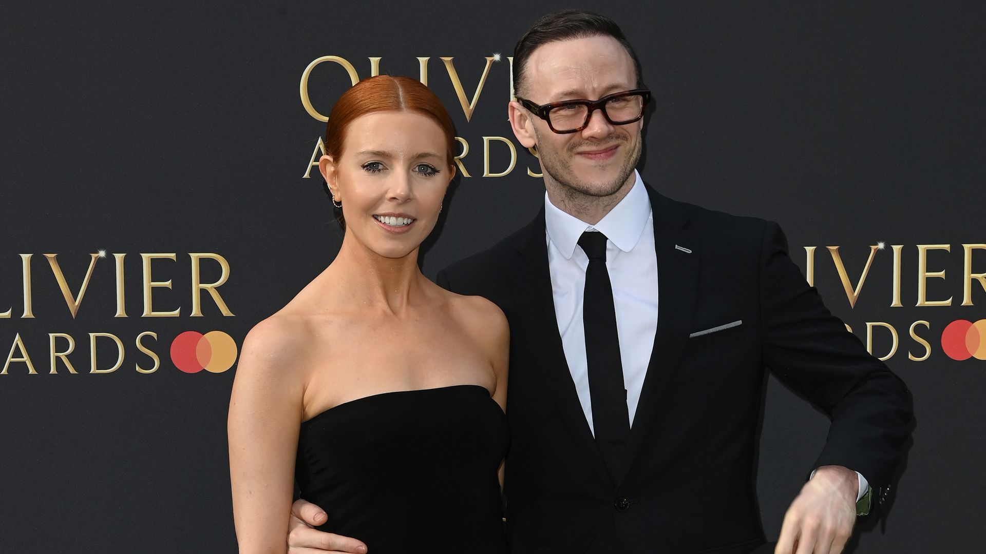 Stacey Dooley in black dress and Kevin Clifton in black suit
