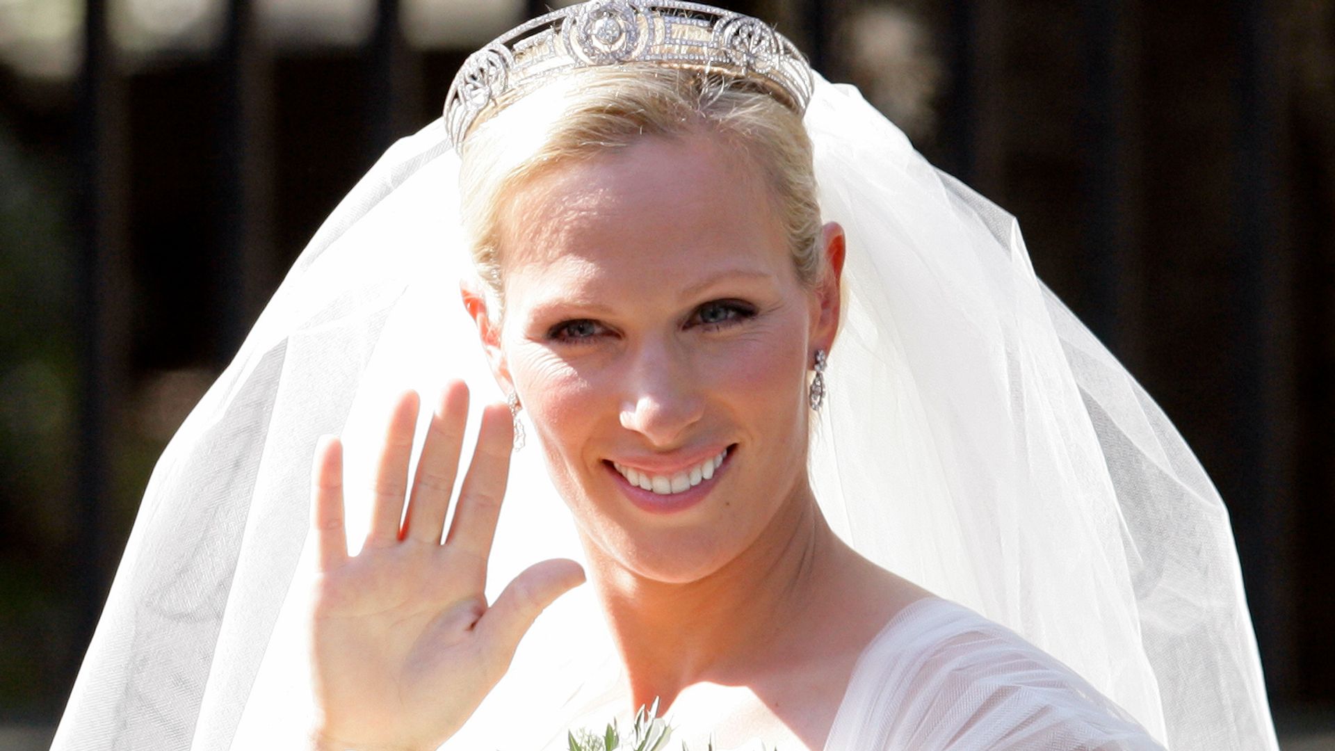 Zara Phillips waves to the crowds as she leaves Canongate Kirk after her wedding to Mike Tindall