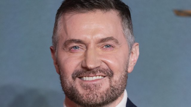 Richard Armitage smiling in a suit