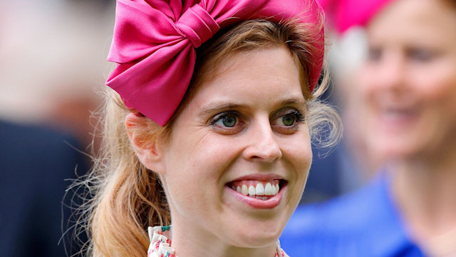 Princess Beatrice smiling in floral dress and pink headband