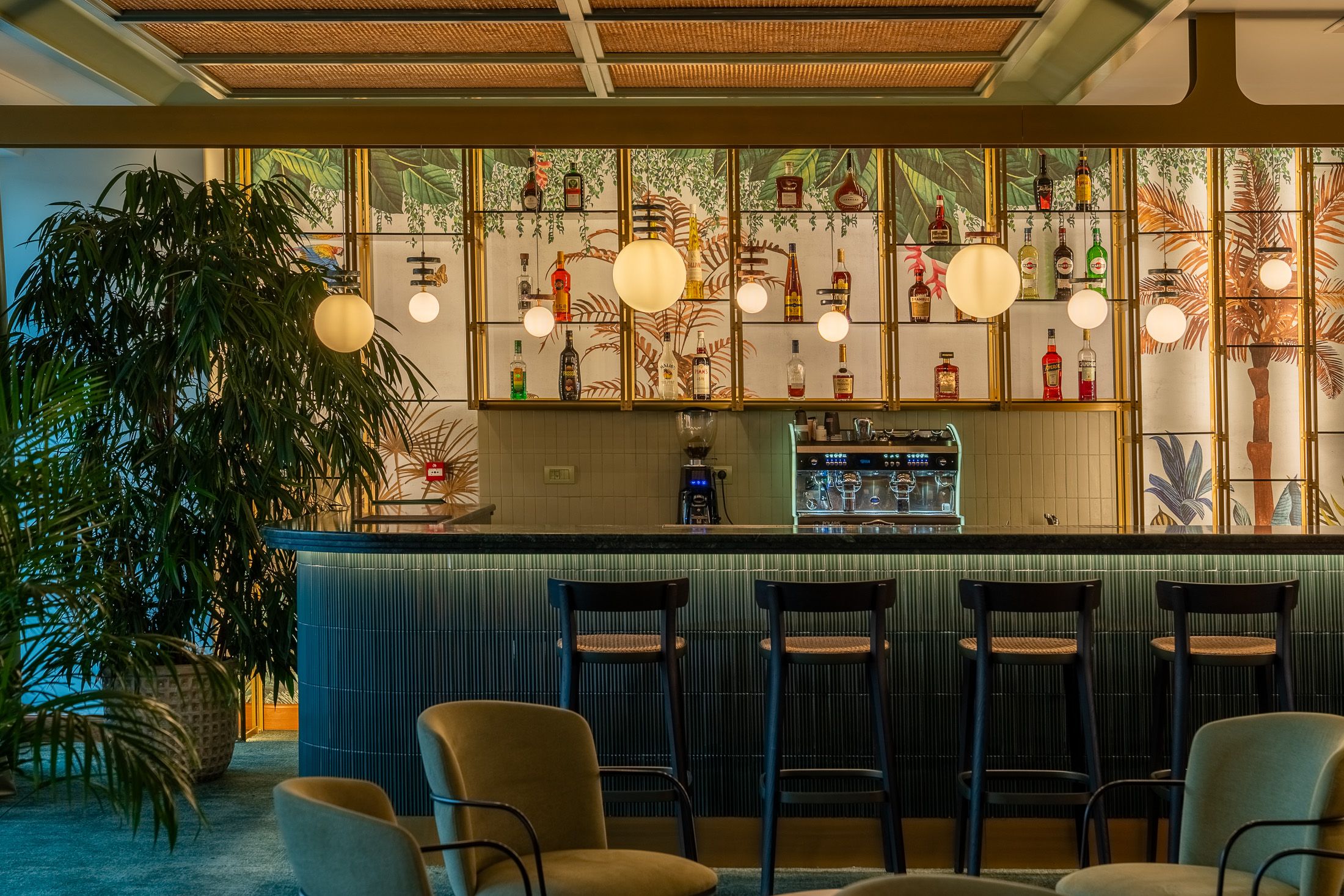 hotel bar in rhodes with chairs plants and hanging lights