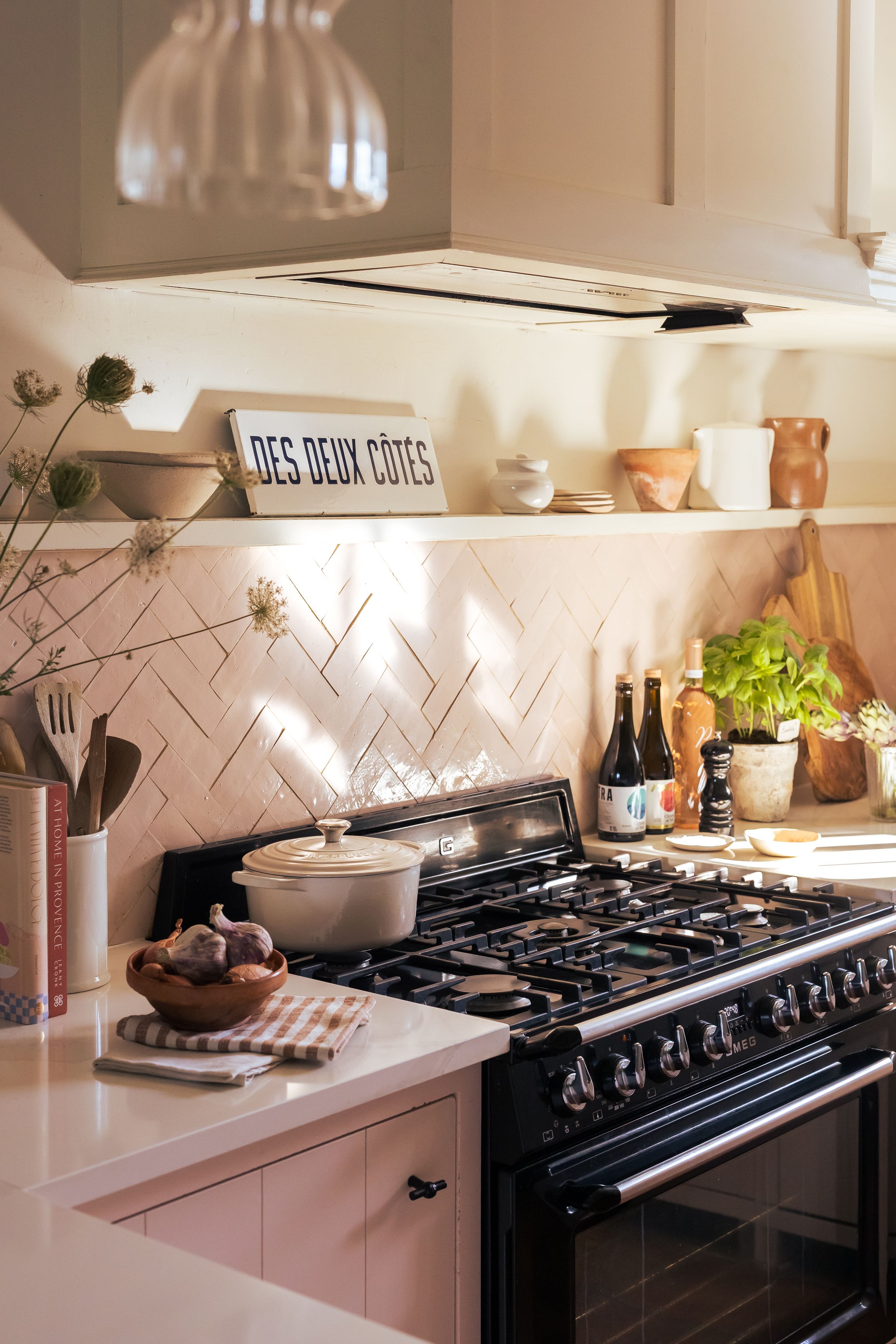The retro-style kitchen with a white and pink colour scheme, and a black cooker in Domaine Mirabeau