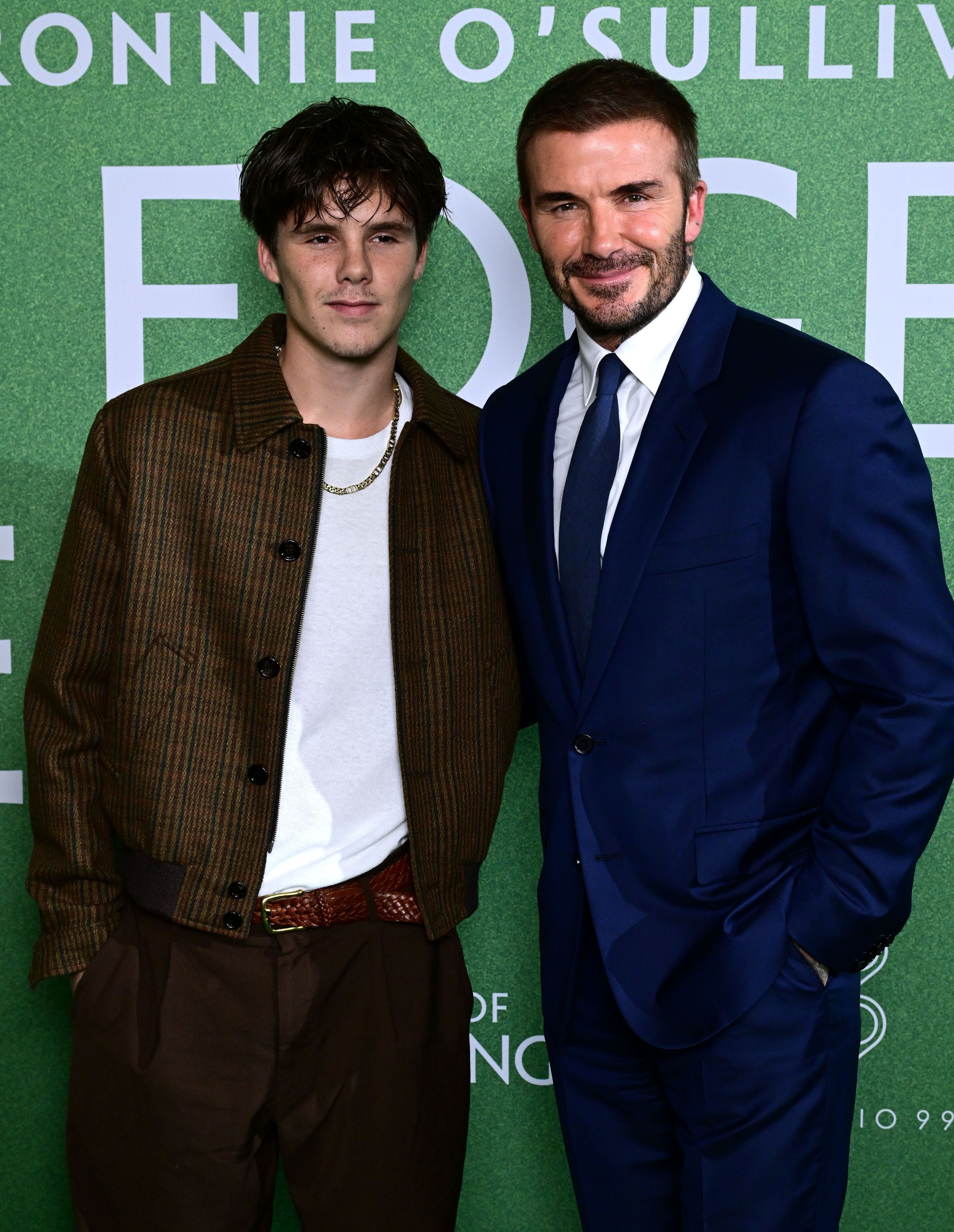 father posing with son at premiere