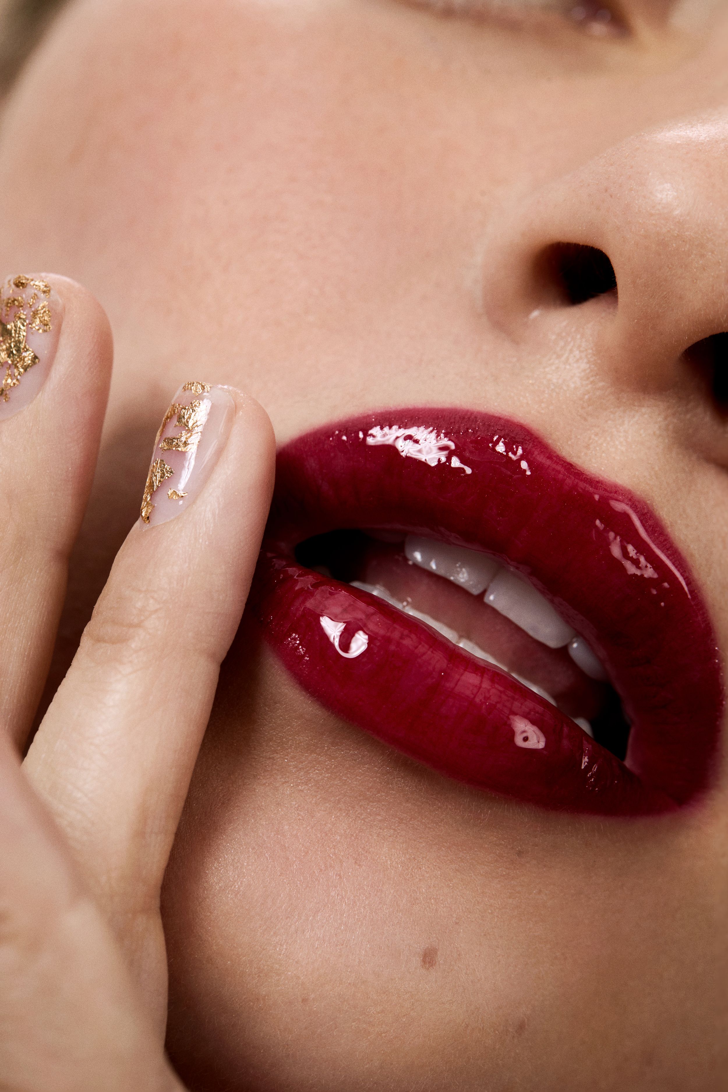close up of ultra glossy lips and embellished nails 