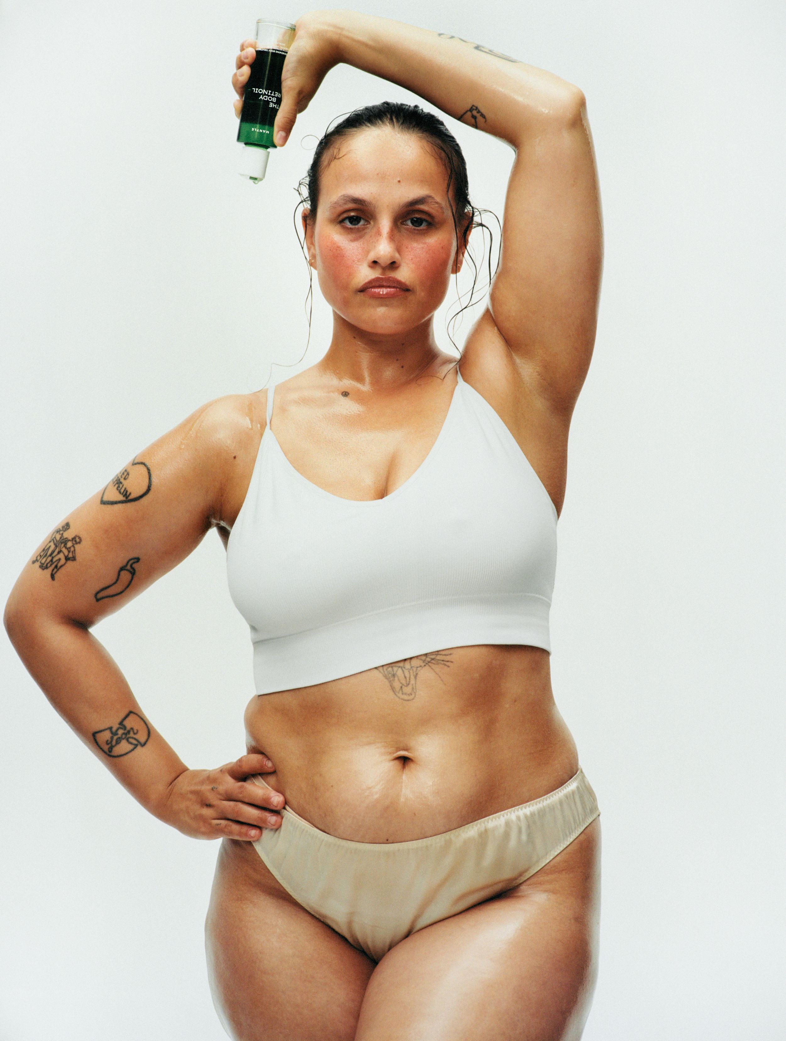 Mantle skincare model in underwear holding a product 