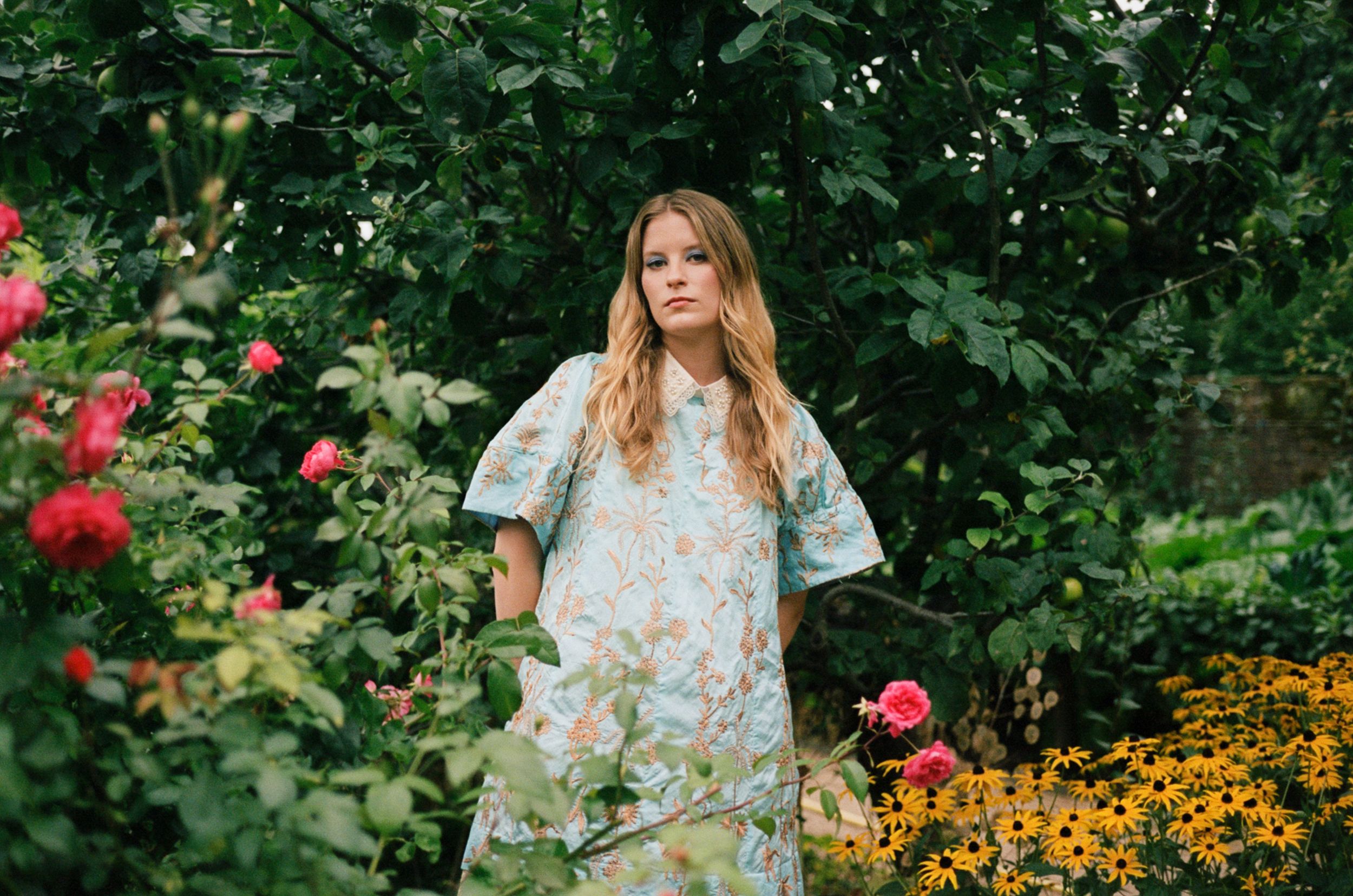 Paris Paloma poses in a Bora Aksu blue floral dress in a garden