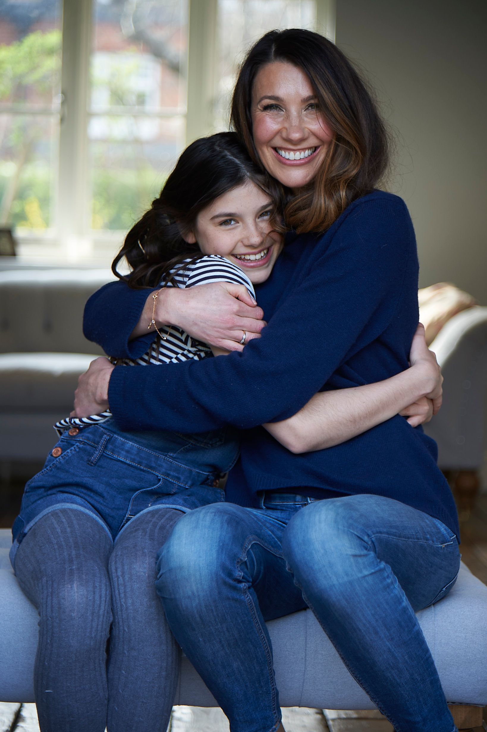 brunette mother and daughter cuddling 