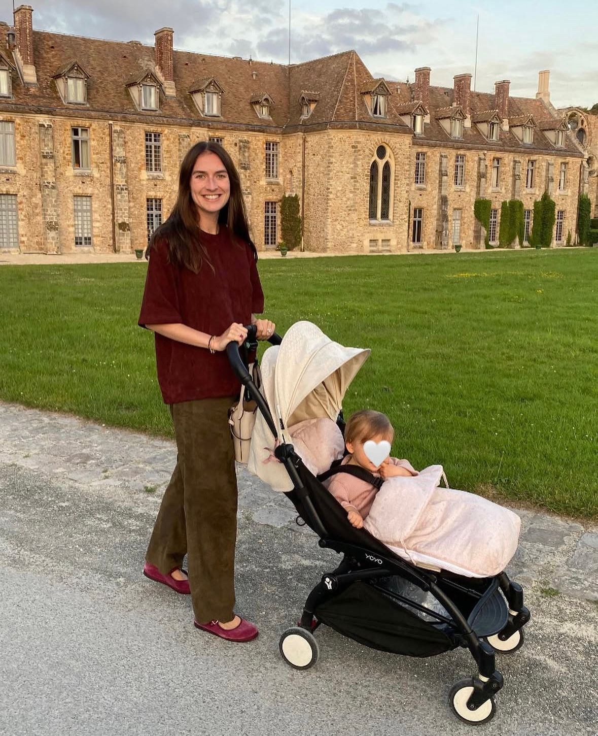 Juliette opts for casual elegance with a wine-hued tee, olive corduroys, magenta ballet flats, and a luxe stroller, epitomizing mom-on-the-go style.​