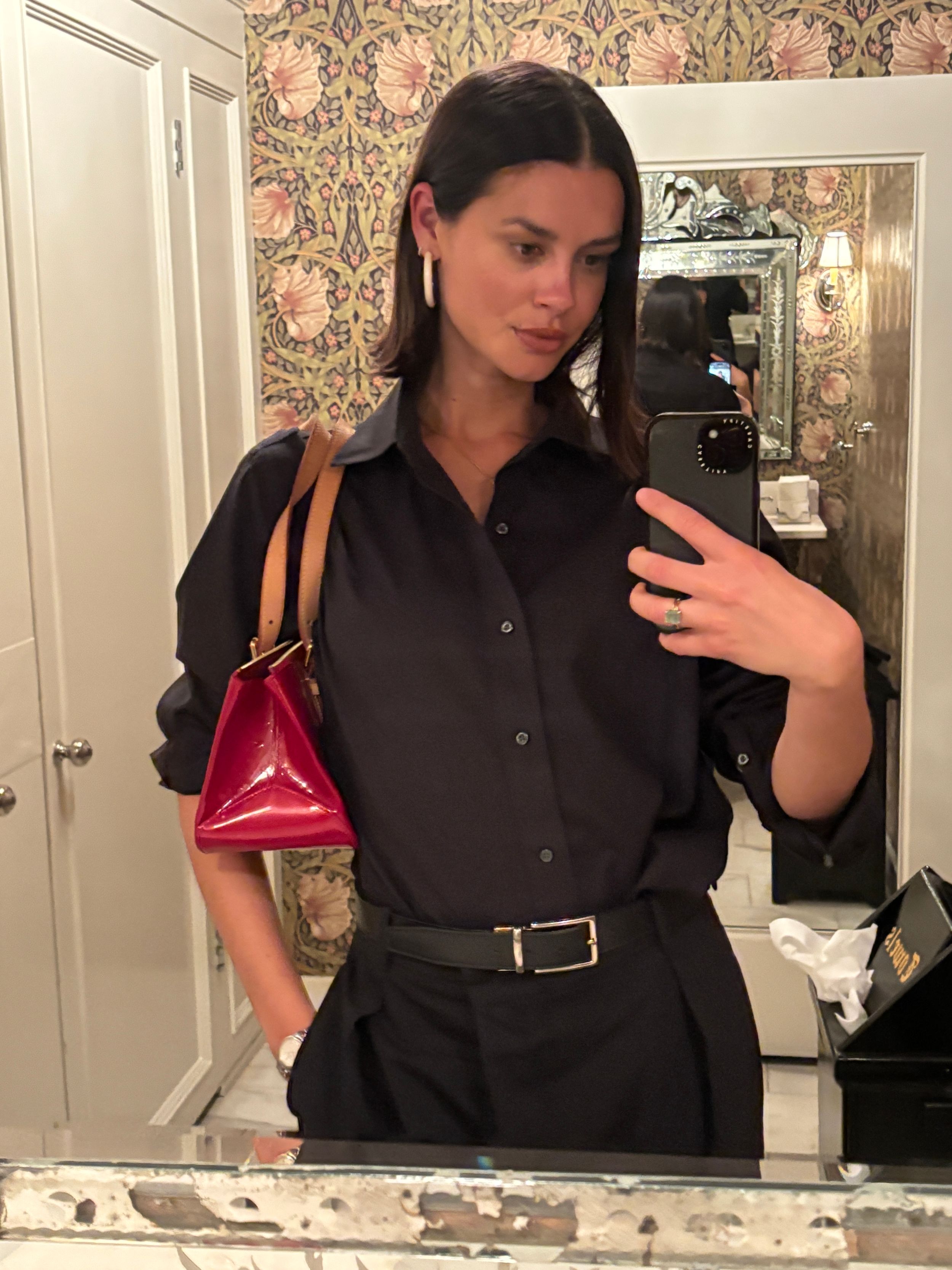 Modèle en chemise noire et sac rouge