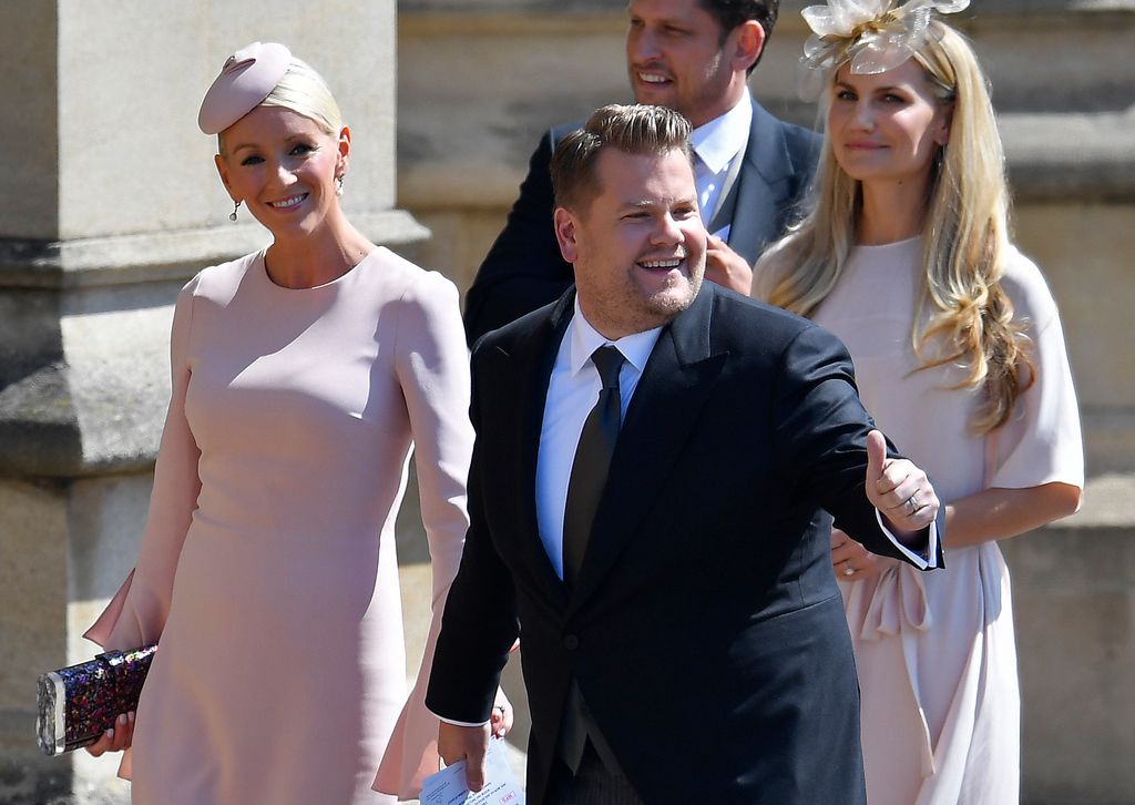 James Corden in black suit with wife Jules in pink dress