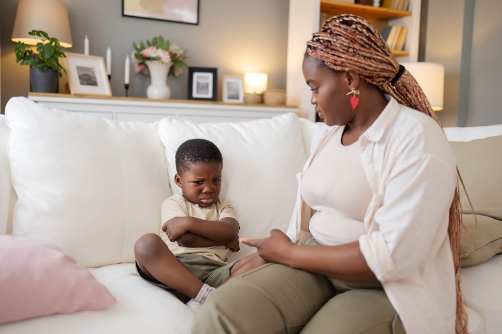 mother and son on sofa with son looking sad