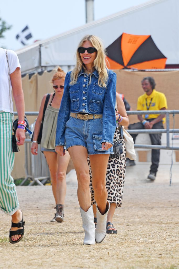 Sienna Miller em jaqueta jeans dupla e shorts curtos no Festival de Glastonbury