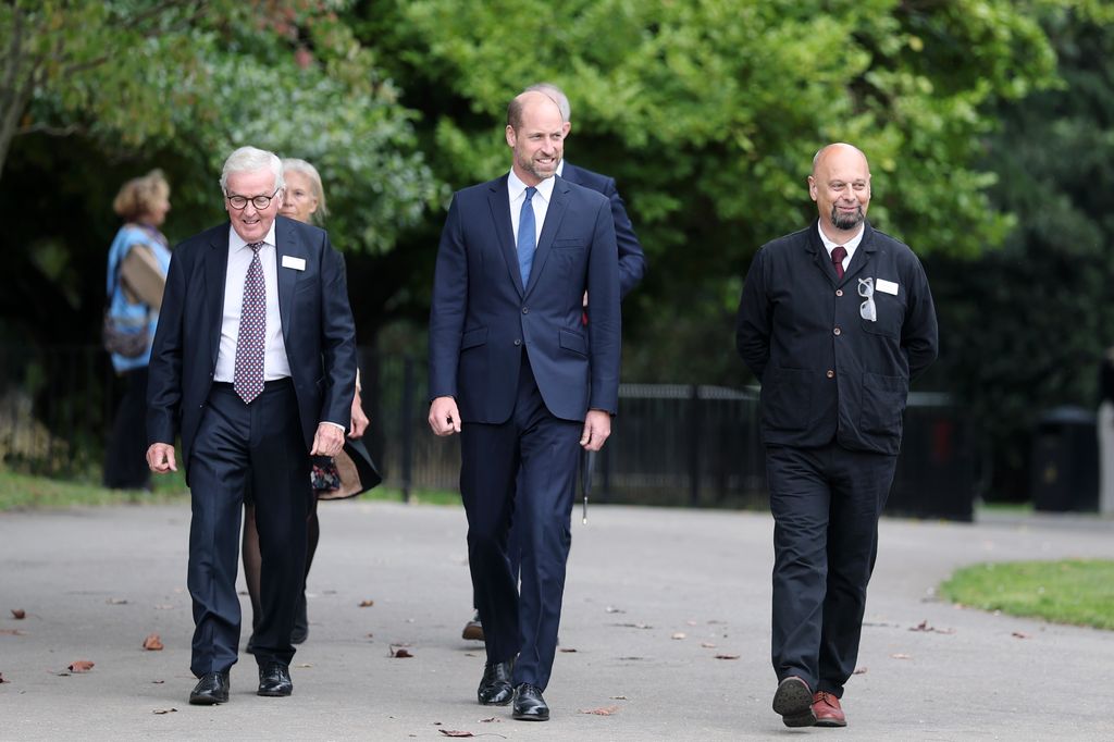 The Prince of Wales walking in park in group of people