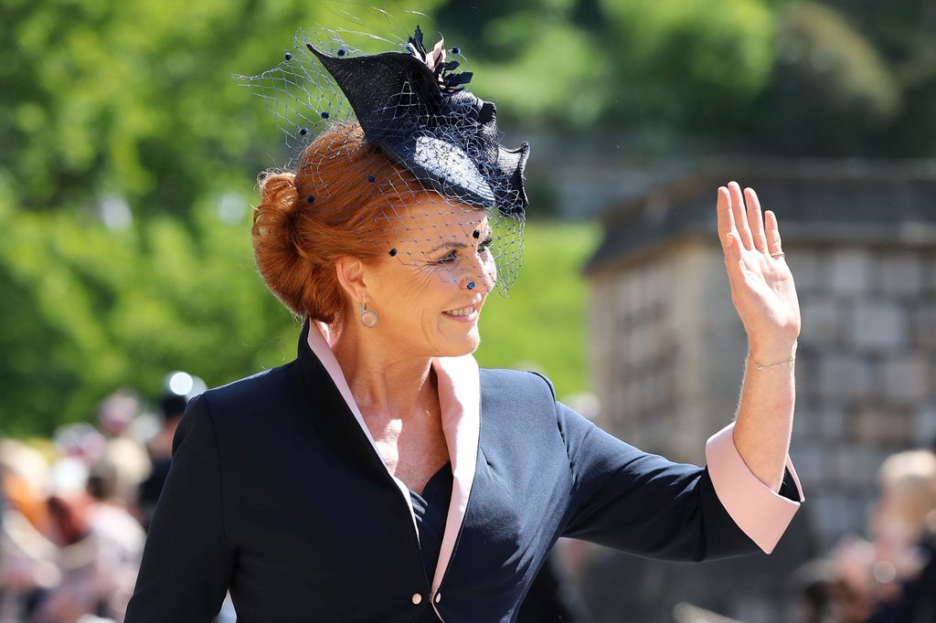 Sarah Ferguson in a black and pink outfit waving at Harry and Meghan's wedding