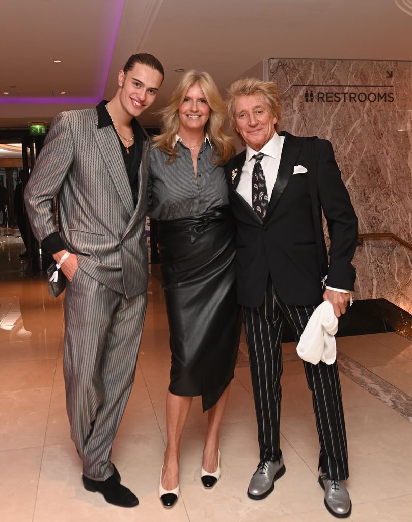 alastair stewart, penny lancaster and rod stewart pose in black and grey outfits