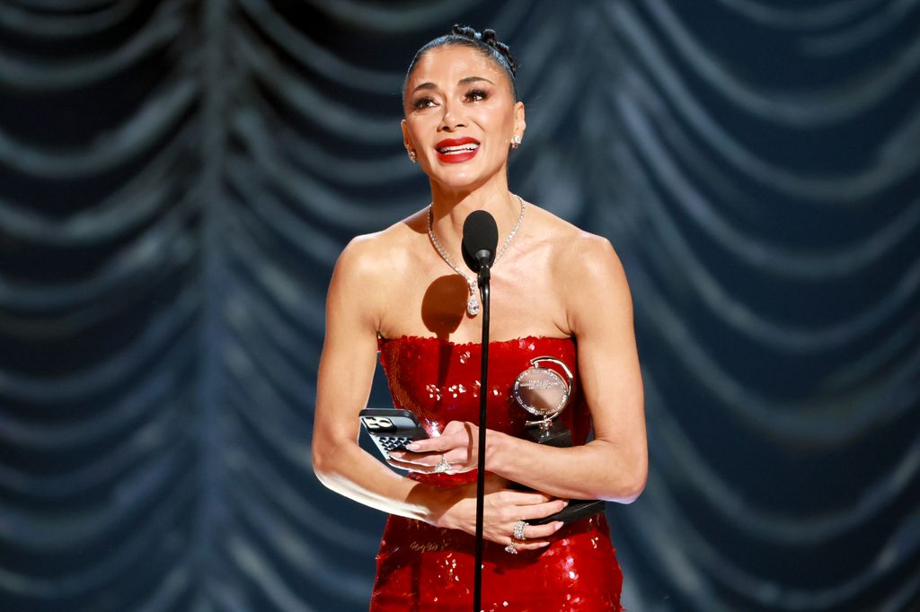 Nicole Scherzinger holding award crying red dress