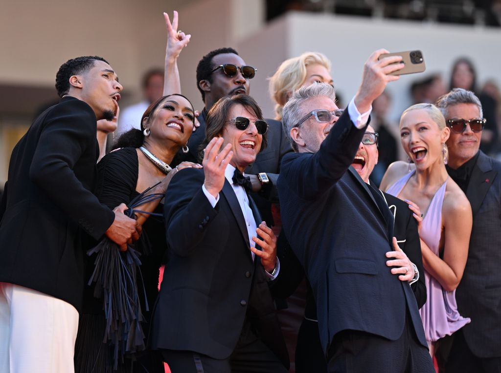 U.S. actor Greg Tarzan Davis, US actress Angela Bassett, US actor and producer Tom Cruise, US actor Tramell Tillman, US film director, screenwriter Christopher McQuarrie, British actor Simon Pegg, British actress Hannah Waddingham, French actress Pom Klementieff, US actor Esai Morales take a group selfie on the steps of the red carpet as they arrive for the screening of the film 'Mission: Impossible - The Final Reckoning' at the 78th edition of the Cannes Film Festival in Cannes, France on May 14, 2025