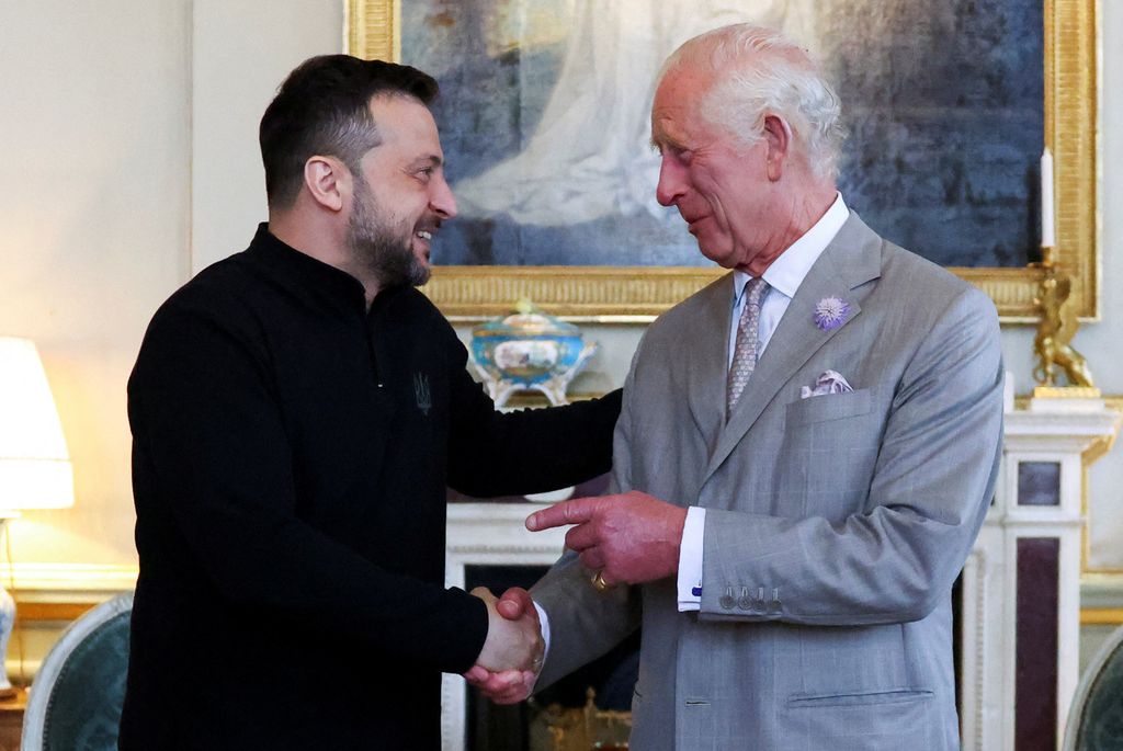 President Volodymyr Zelensky shaking hands with King Charles; the duo are smiling