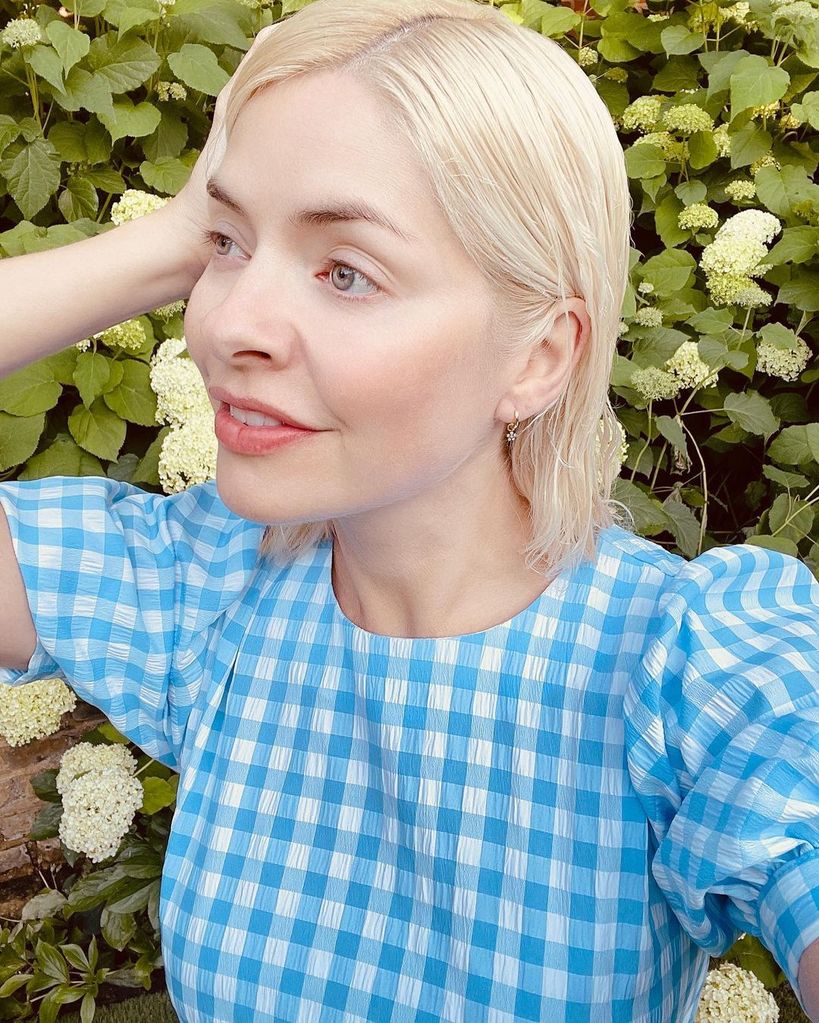 Holly Willoughby in gingham dress posing in garden with wet hair