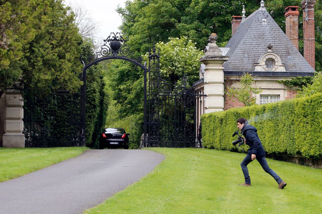 2N4RJGY A member of the media runs as a car arrives at the entrance of Wideville Castle belonging to Italian Fashion designer Valentino where Kim Kardashian, Kanye West are awaited, in Davron, 35 miles west of Paris, Friday, May 23, 2014. The gates of the Chateau de Versailles, once the digs of Louis XIV, will be thrown open to Kim Kardashian, Kanye West and their guests for a private evening on the eve of their marriage. (AP Photo/Francois Mori)