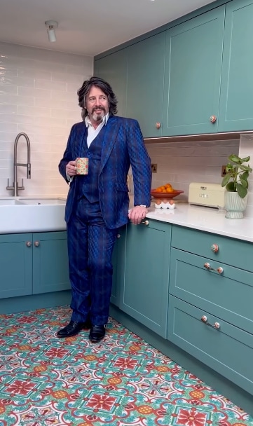 man in blue suit in teal kitchen