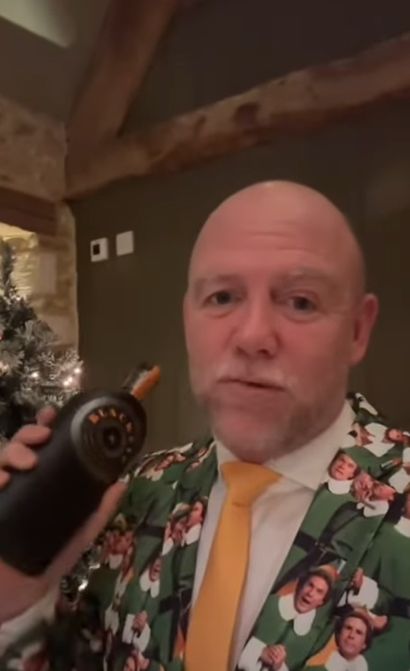 Mike Tindall wearing a 'Buddy the Elf' suit and standing next to a Christmas tree