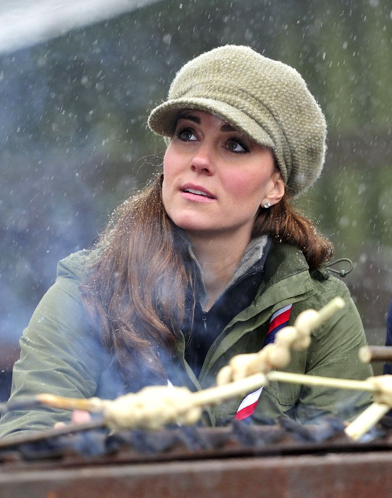 Catherine, Princess of Wales bergabung dalam membuat makanan api unggun selama kunjungan ke Great Tower Scout Camp di Newby Bridge di Cumbria pada 22 Maret 2013. Kondisi bersalju yang berani untuk berkunjung ke kamp pengintai.