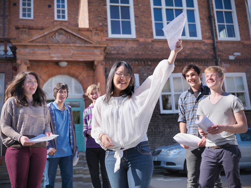 Portrait of student and colleagues receiving exam results