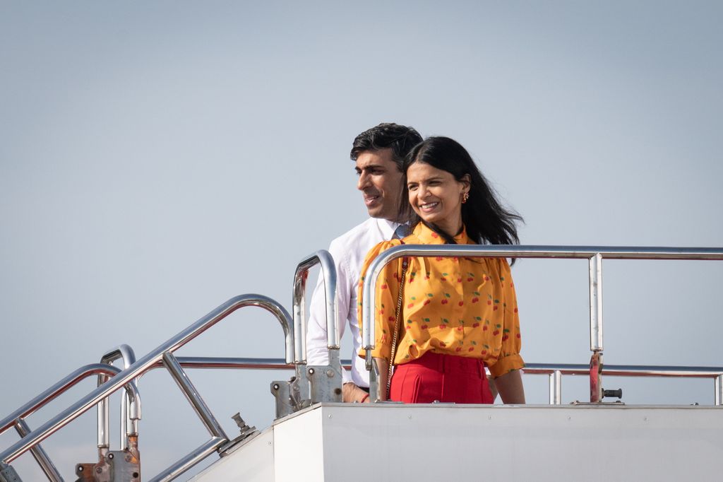 HIROSHIMA, JAPAN - MAY 21: British Prime Minister Rishi Sunak and wife Akshata Murty wave as they prepare to board a plane following the G7 summit on May 21, 2023 in Hiroshima, Japan. The G7 summit was held in Hiroshima from 19-22 May. (Photo by Stefan Rousseau - WPA Pool/Getty Images)