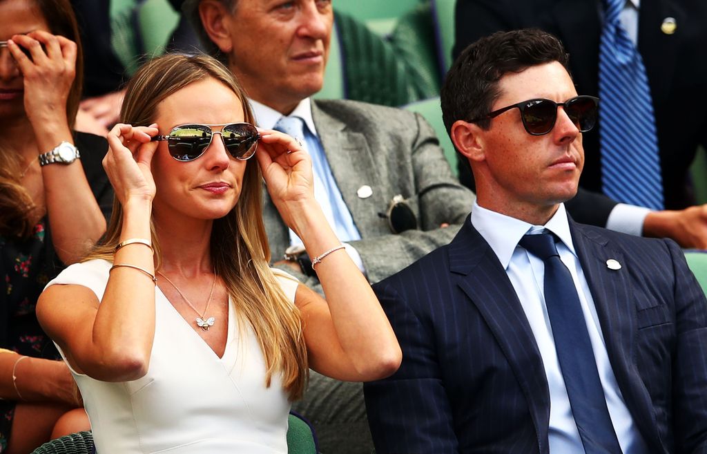 Erica Stoll and Rory McIlroy looking disappointed while wearing sunglasses