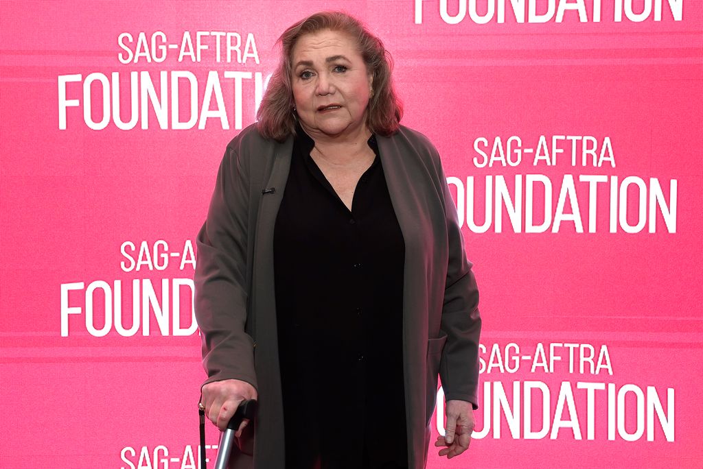 Kathleen holding a walking stick in 2024