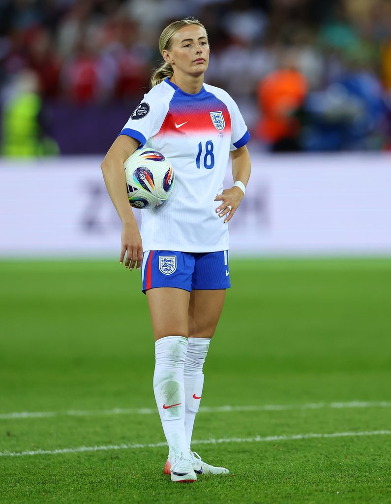 Chloe Kelly holding a football in an England kit