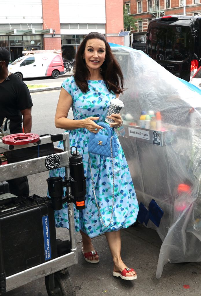 Kristin Davis wearing a blue dress and a blue Chanel bag as she is seen on the set of "And Just Like That" on June 05, 2024 in New York City