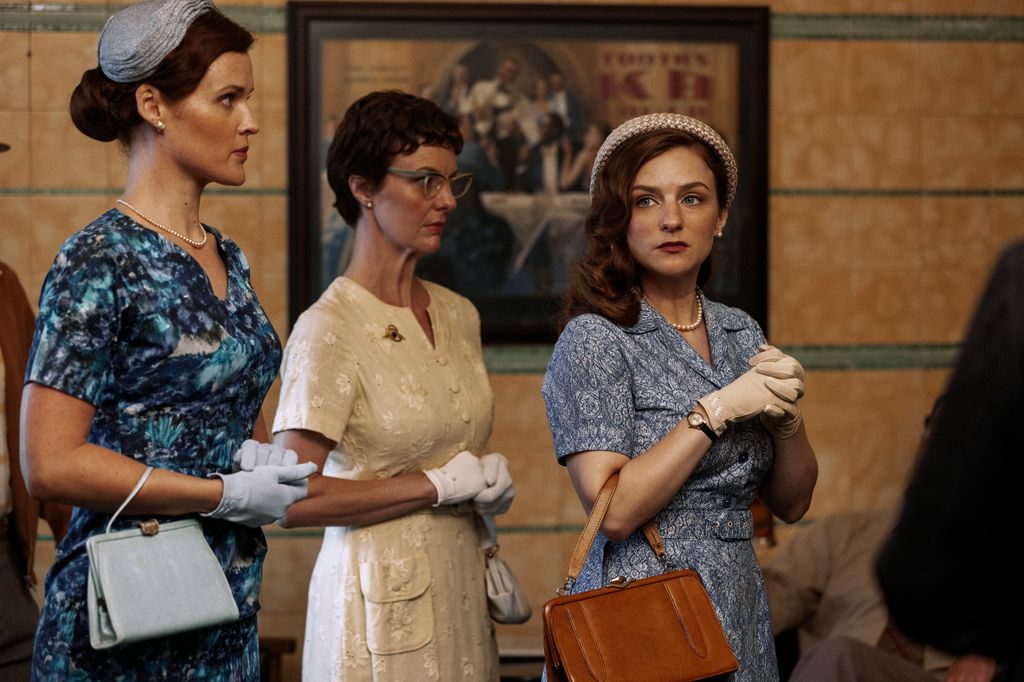 Three women in period clothing standing in line