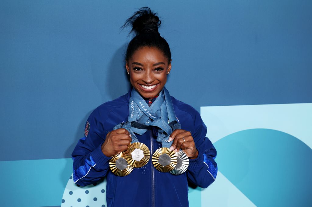 Simone Biles holds the 2024 Olympic medals in her hands