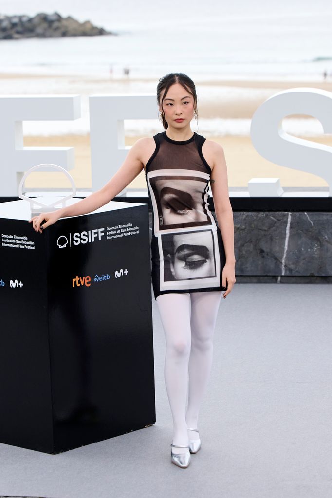 Actress Chacha Huang wears eye-graphic mini dress  The black mesh overlay gave the print a sheer, futuristic twist, paired with white tights and metallic heels. 