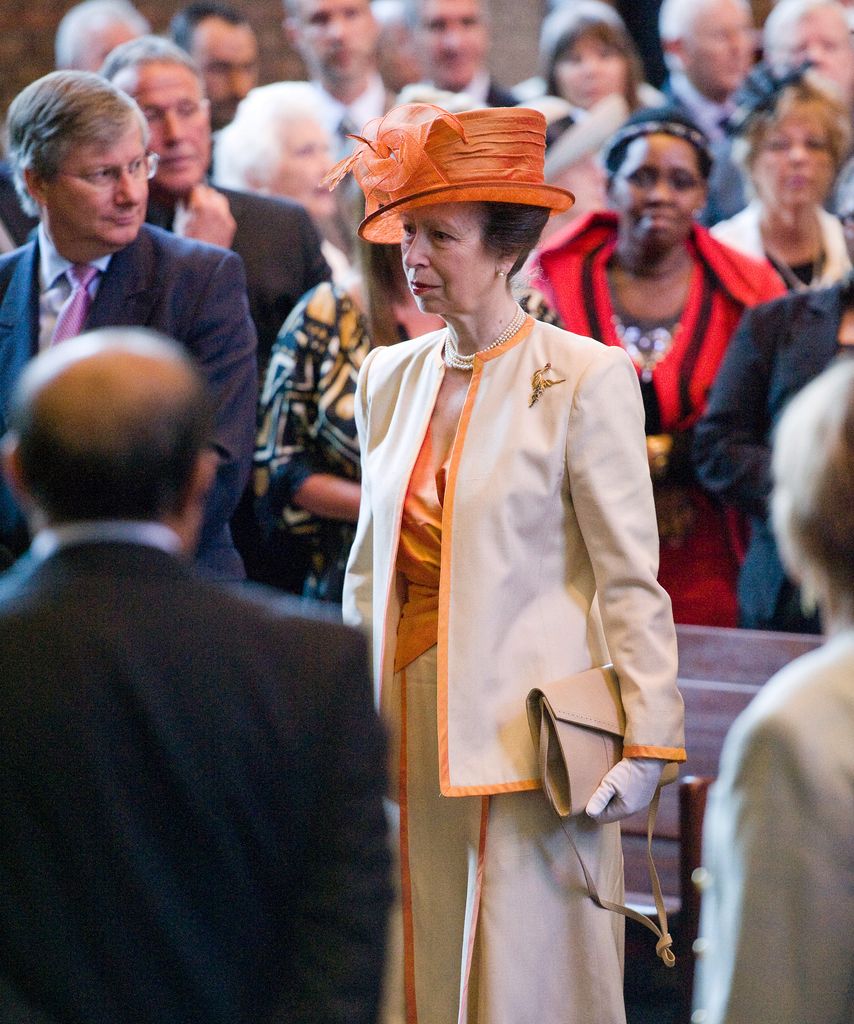 Princess Anne in an orange skirt suit and orange hat