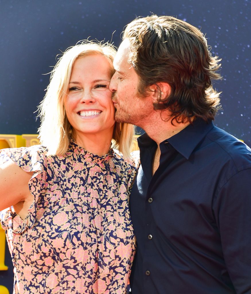 Oliver Hudson  kissing a smiling Erinn Bartlett on the cheek