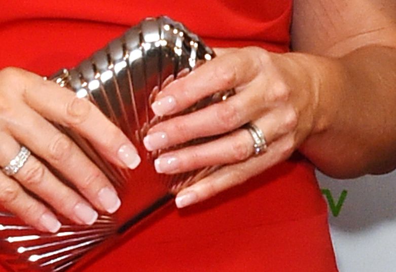 Ruth Langsford in a red dress holding a silver clutch