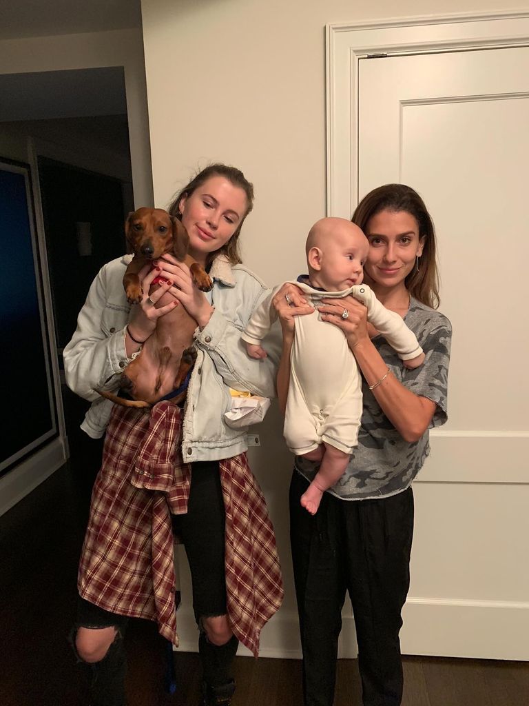 photo of ireland baldwin holding a dog and hilaria baldwin holding a baby