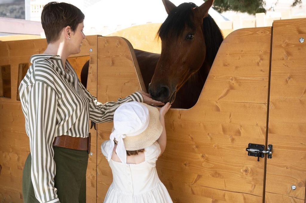 Princess Charlene feeds a horse with her daughter Princess Gabriella