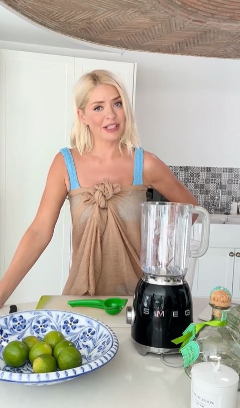 Holly Willoughby in a kitchen in blue bikini and sheer gown