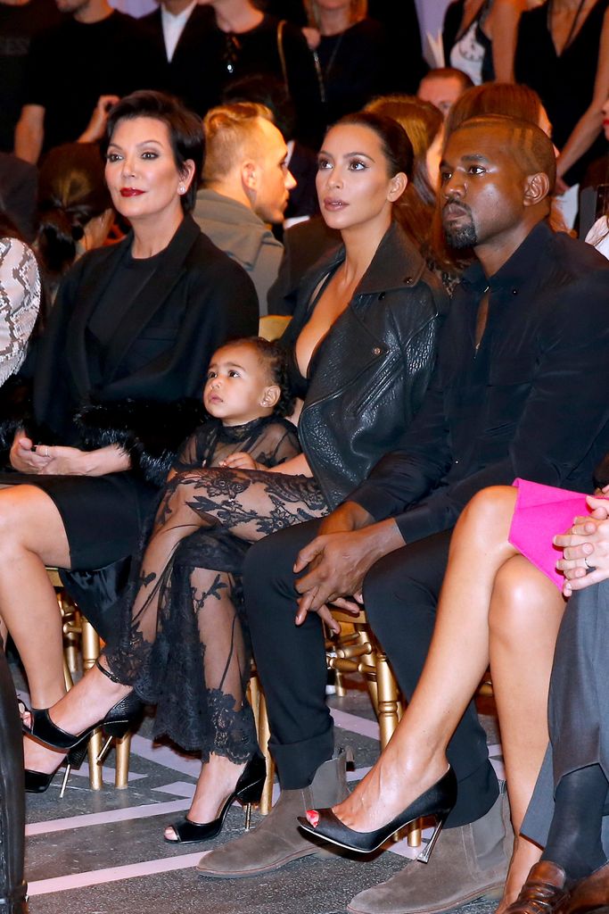 A toddler North West sat with her mom, dad and grandmother in a front row at Paris Fashion Week 2014