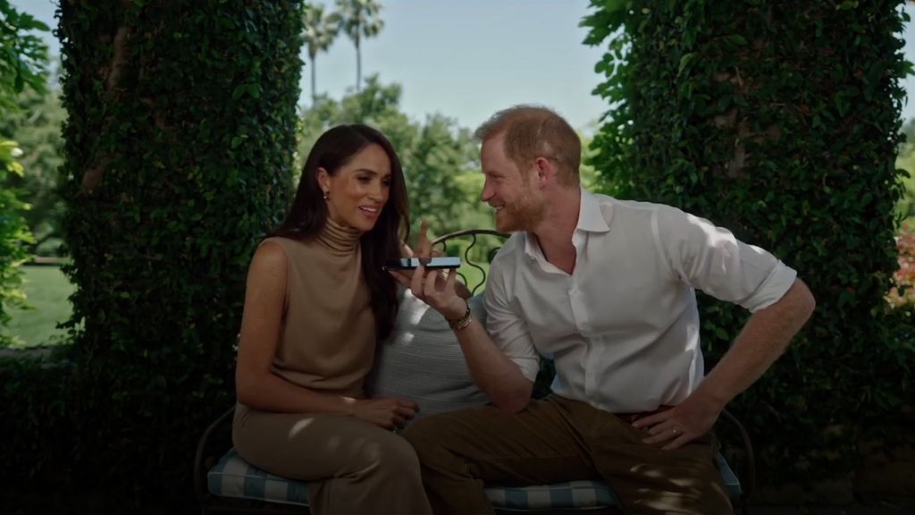 Harry and Meghan smiling at each other in garden