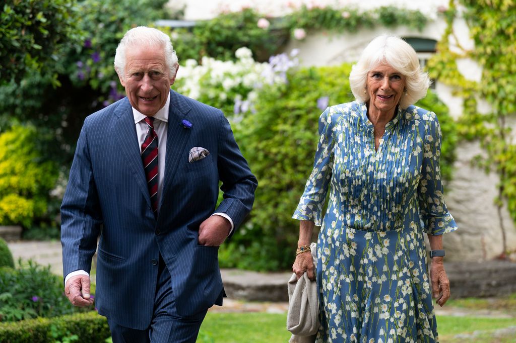 King Charles and Queen Camilla walking in a garden