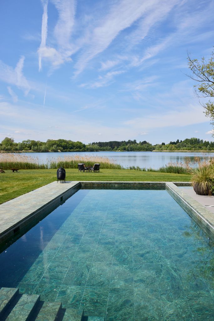 an outdoor pool with a lake backdrop