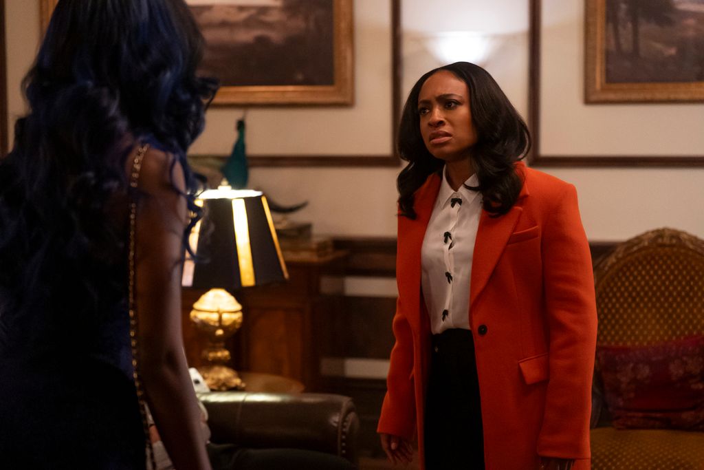 woman in red coat looking at another woman in doors