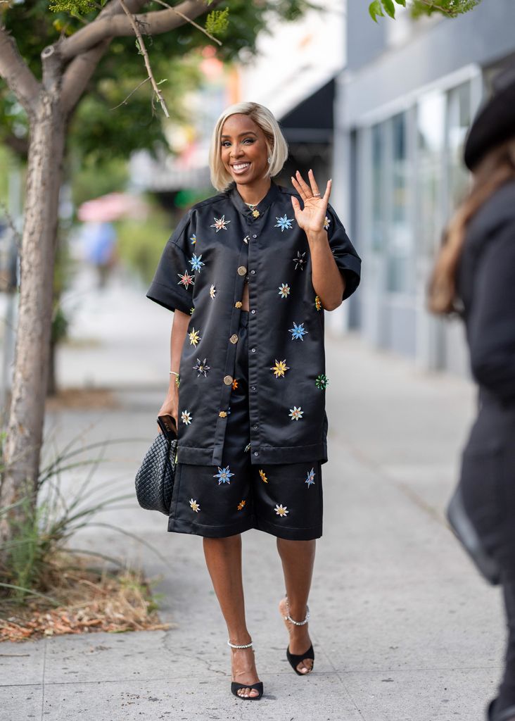 Kelly Rowland waving in black ensemble