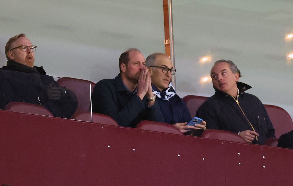 Prince William watching football with his hands in front of his mouth